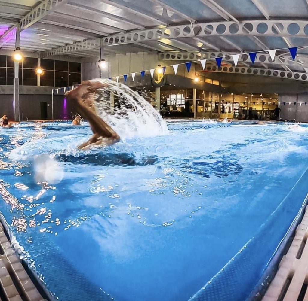 Swimmer in an indoor pool turning at the end of the lane