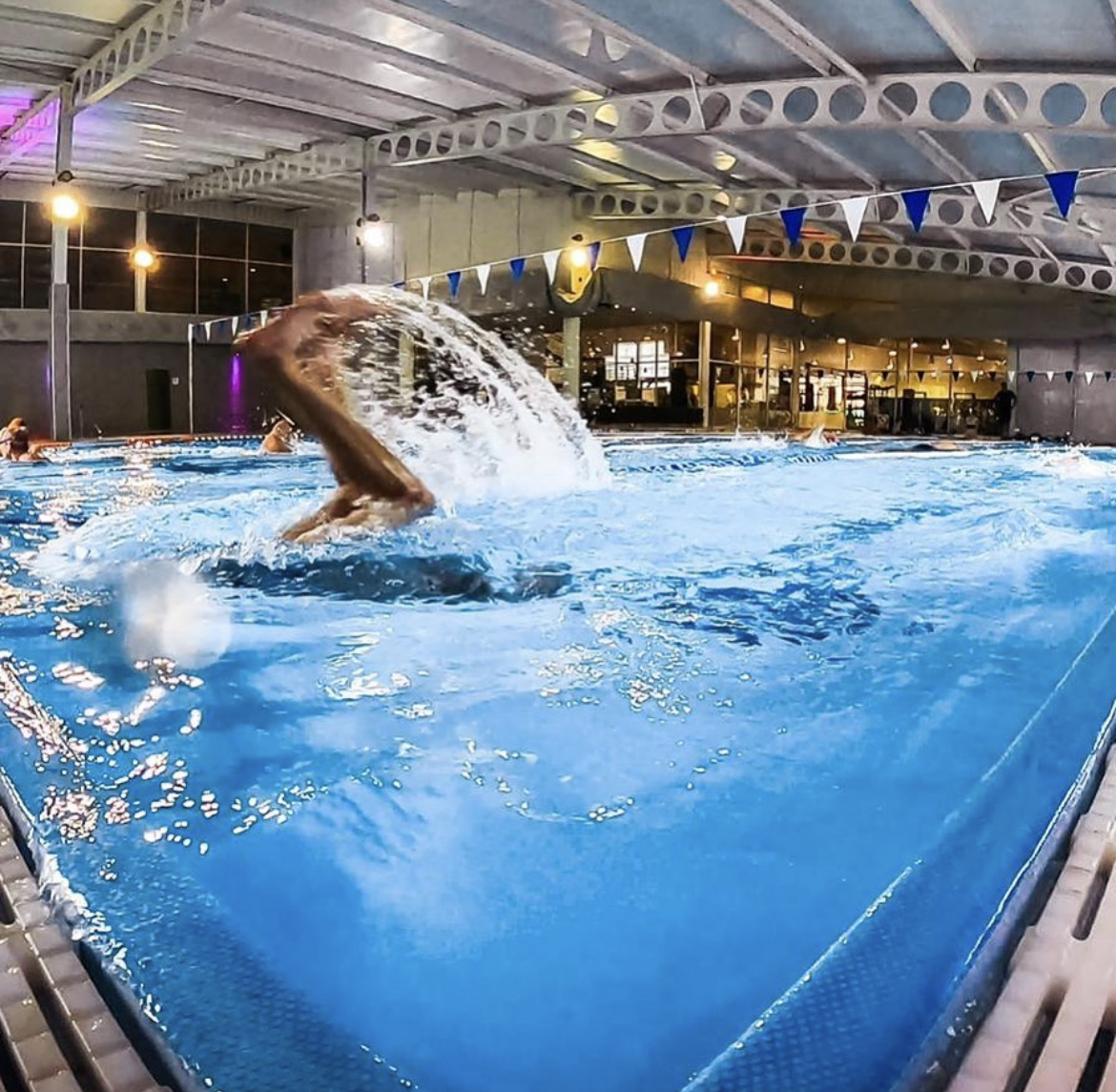 Swimmer in an indoor pool turning at the end of the lane