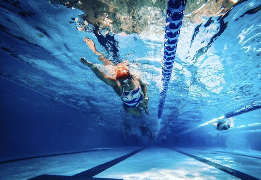 Female swimmer in the pool taken from underneath