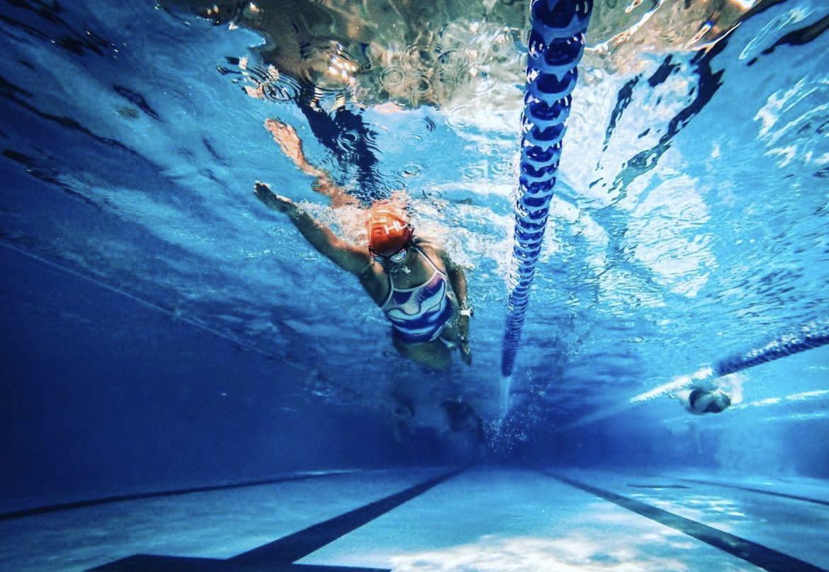 Female swimmer in the pool taken from underneath